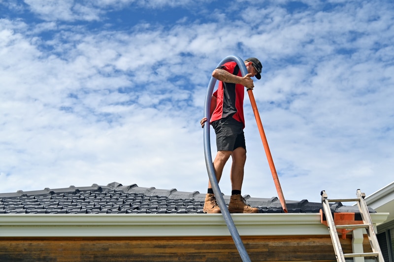 Man on top of a roof cleaning